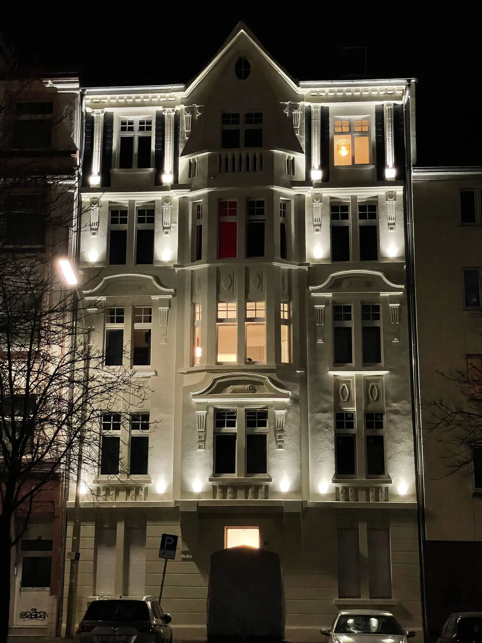 The illuminated facade of Gneisenaustraße 93 in the evening