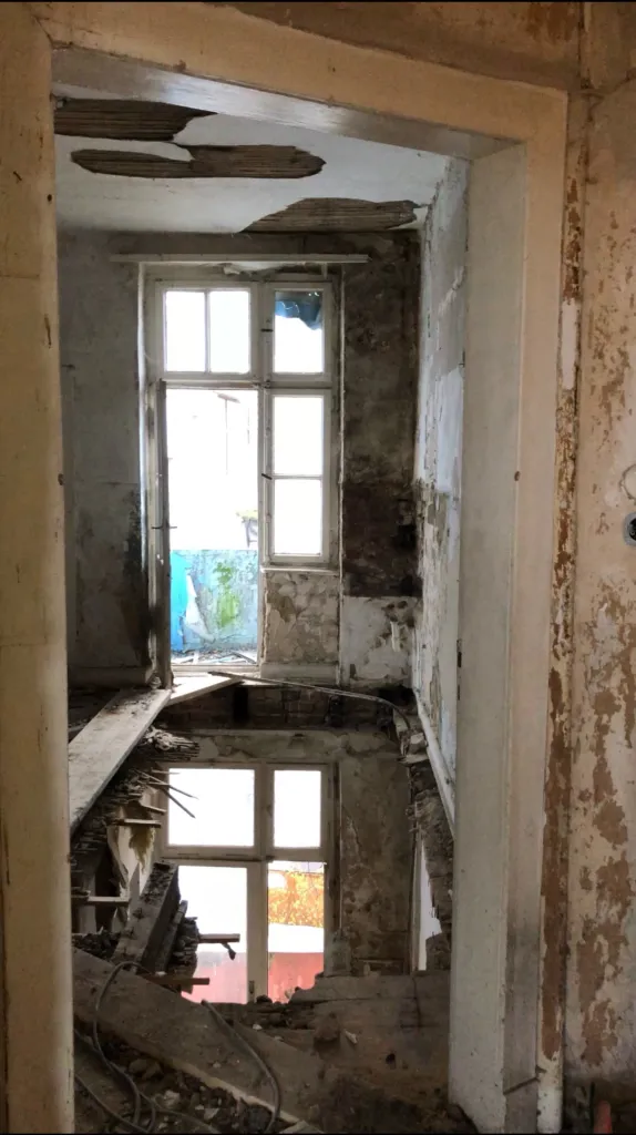 View through a doorway onto collapsed ceilings and rubble